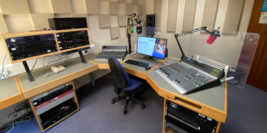 Radio equipment including computer screen and radio desk.