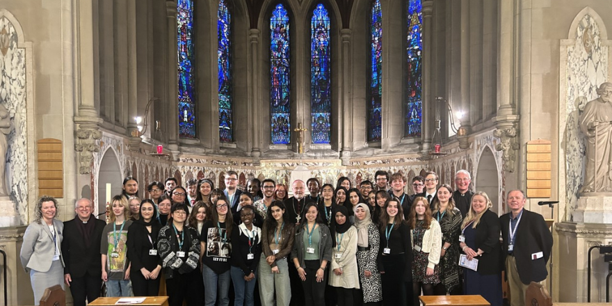 students and staff standing together in a chapel for a photograph